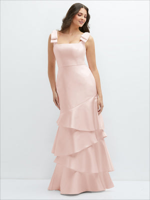 Blush pink bow-shoulder satin maxi dress, three-quarter front view, tiered skirt