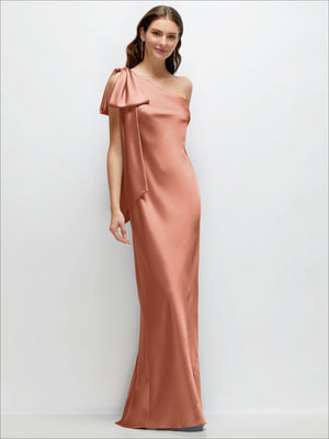 Ballet pink one-shoulder satin maxi dress with cascading shoulder bow, bias-cut drape