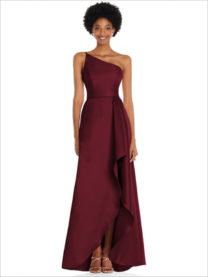 One-shoulder satin gown in deep burgundy with draped front slit and pockets.