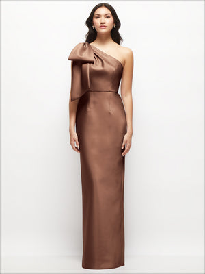 Brown one-shoulder satin maxi dress with oversized bow detail at shoulder and sleek column fit