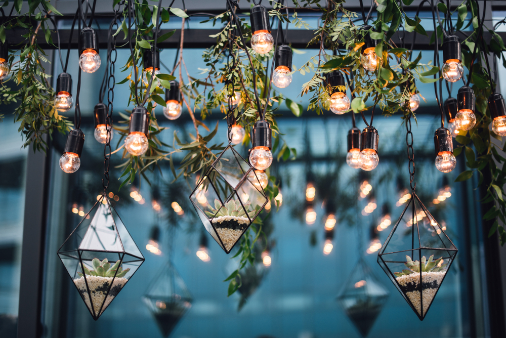 Hanging terrariums and white string lights at a wedding reception