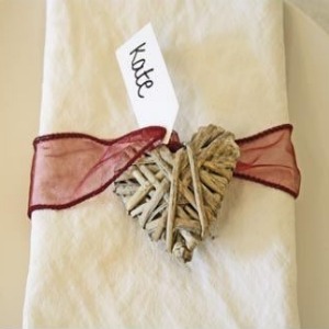 napkin tied with heart and bow for table setting at wedding