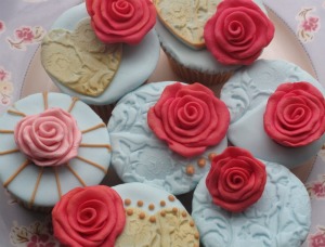 red and blue iced cupcakes with roses
