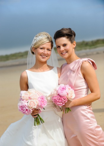 bride and bridesmaid with pink roses bouquets