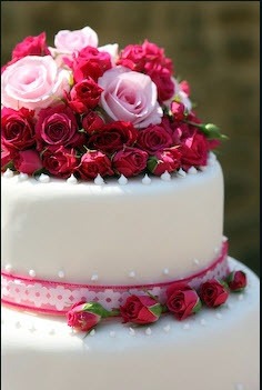 wedding cake decorated with dark pink roses 