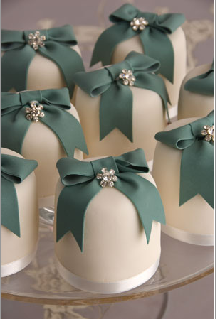 Small cakes decorated with green ribbon bows and diamante