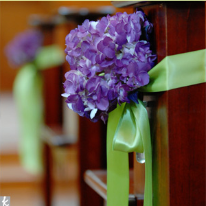 purple hydrangeas decorating pews in church at wedding 