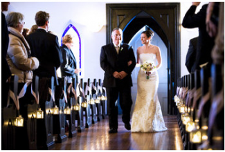 candles lining aisle in church at wedding 