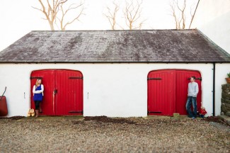 engagement photos with couple by red barn doors 