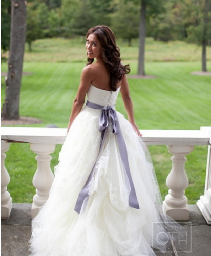 Bride in wedding dress with purple sash 
