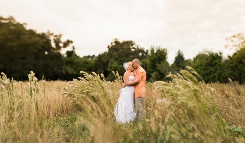 bride and groom in meadow at rustic wedding 