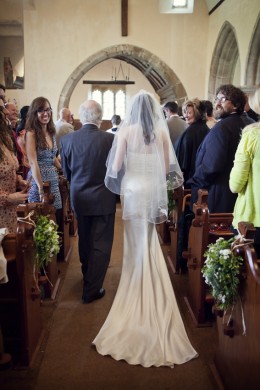 bride walking up church aisle with father