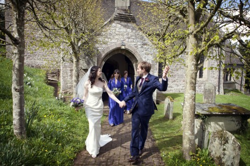 bride and groom outside old stone church