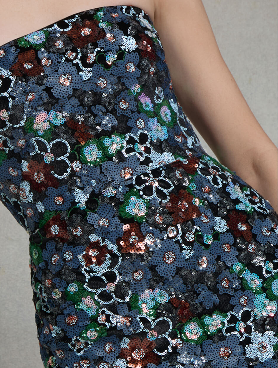 Close-up of blue and green floral fabric on a fitted gown.